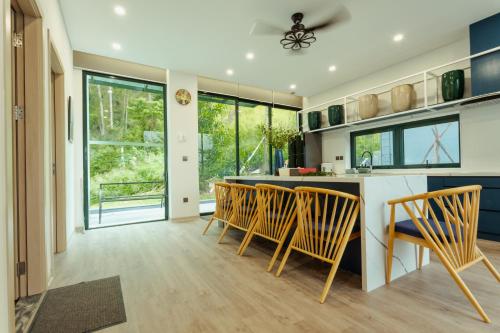 a kitchen with wooden chairs and a kitchen island at FLAMINGOS Villa Happy 3 phòng ngủ- view Hồ- bể bơi riêng in Ngọc Quang