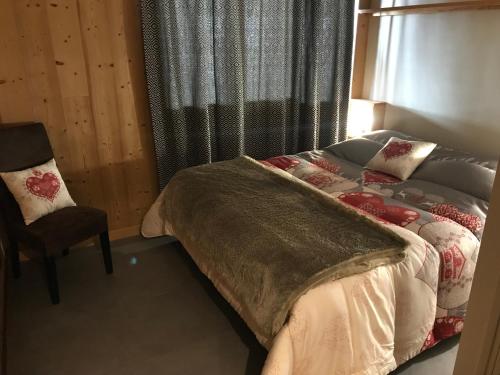 um quarto com uma cama, uma cadeira e uma janela em Résidence LE BEC DE L AIGLE - N°15 em Laveissière