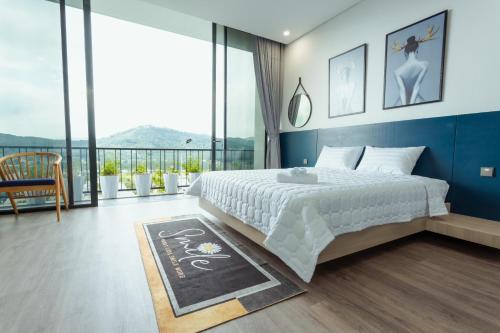 a bedroom with a large bed and a large window at FLAMINGOS Villa Happy 3 phòng ngủ- view Hồ- bể bơi riêng in Ngọc Quang