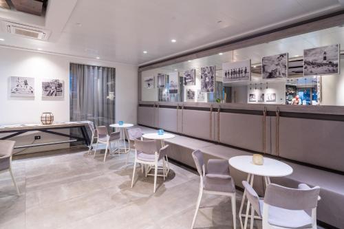 a restaurant with tables and chairs and a counter at Nautilus Family Hotel in Pesaro