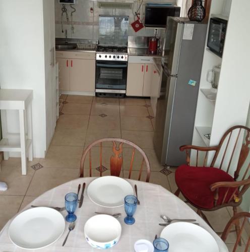 a kitchen with a table with white plates on it at TONGOY CASA INTIMA Y FAMILIAR in Coquimbo