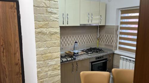 a kitchen with white cabinets and a stove top oven at La Nik in Lupeni