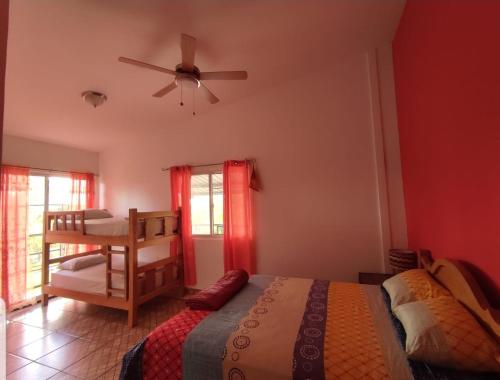 una camera con letto e ventilatore a soffitto di Rainforest Lodge del Rio a Portobelo