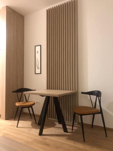 a table and two chairs in a room at Apartmani G8 in Pale