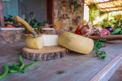 a cutting board with cheese and a knife on it at L'Oasi del Cervo in Arbus