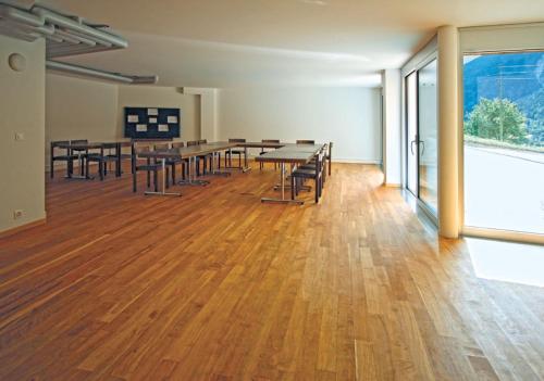 an empty room with tables and chairs and a large window at BerglandHof Hotel Ernen in Ernen