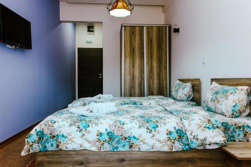 a bedroom with a large bed with blue walls at Verdisso Hotel & Restaurant in Demir Kapija