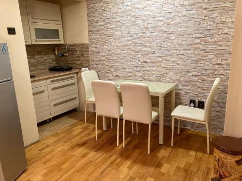 a kitchen with a table and chairs and a brick wall at Szent János Vendégház in Eger