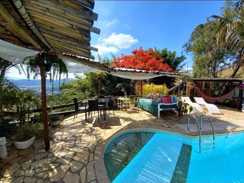 ein Haus mit einem Pool und einer Terrasse in der Unterkunft Espaço Luz Helga Ferreira in Vassouras
