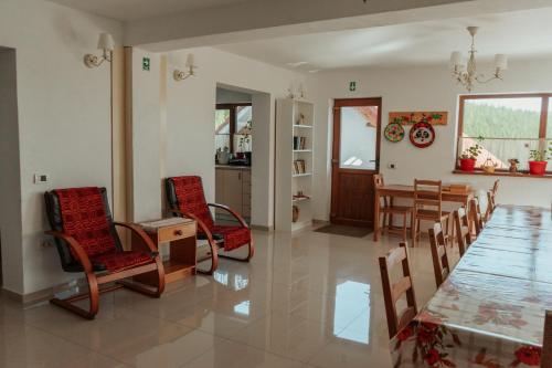 a dining room and living room with a table and chairs at Casa Bunicutei in Ranca