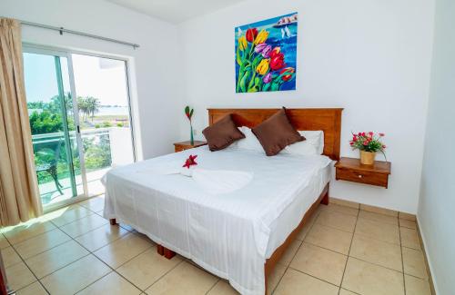 a bedroom with a large bed and a large window at Hotel Casa Pridda in Puerto Escondido
