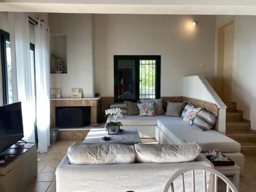 a living room with a couch and a table at Villa Skyfall in Kalamitsi