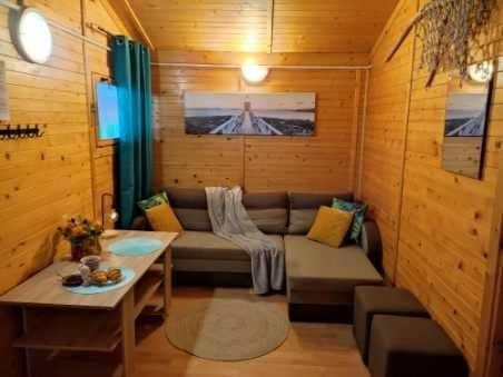 ein Wohnzimmer mit einem Sofa und einem Tisch in der Unterkunft Domki letniskowe Alma, Wicie in Vitte