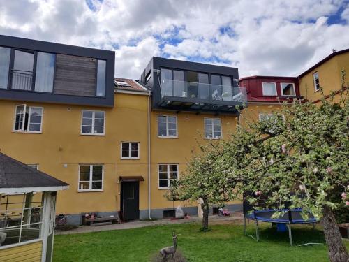 卡爾馬的住宿－Lyxig vindsvåning nära Kalmar slott och havet，黄色的建筑,上面设有阳台