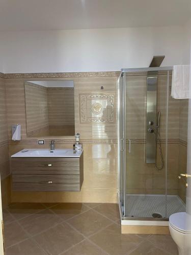 ein Badezimmer mit Dusche, Waschbecken und Toilette in der Unterkunft Corte Vena in Bianco