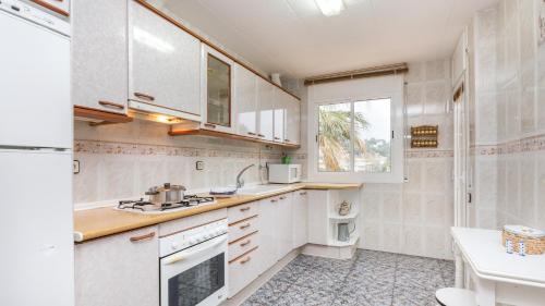 een keuken met witte apparatuur en een raam bij 2Vil01 - Lloret de Mar in Lloret de Mar