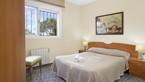 a bedroom with a bed and a chair and a window at 2Vil01 - Lloret de Mar in Lloret de Mar