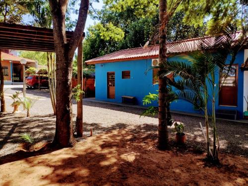een blauw gebouw met bomen ervoor bij Suits - Canto do sabia in Brotas