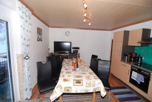 ヘルマゴルにあるHaus Martlのテーブルと椅子、キッチンが備わる客室です。