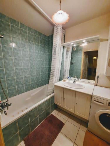 une salle de bain avec un lavabo, une baignoire et un miroir dans l'établissement Entre Lac d'Annecy et montagnes, golf et parapente à pieds, à Talloires