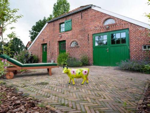 a toy cow in front of a brick house at Doppelzimmer Holthusen 25515 in Weener