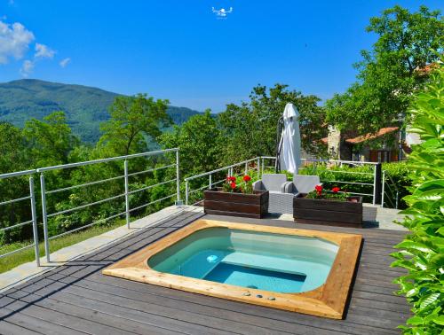 a plunge pool on a wooden deck with a chair and an umbrella at Agriturismo Vezzano in Chiusi della Verna