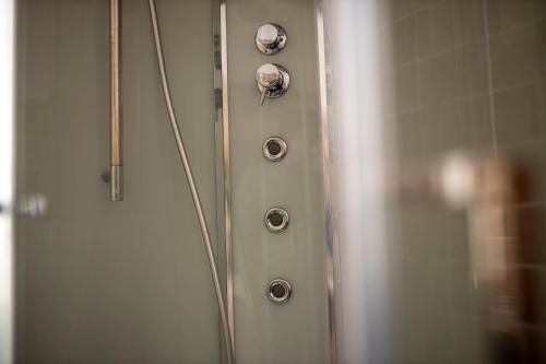 a shower door with two knobs on it at IL PALAZZO - Luxury Home & Event in Cosenza