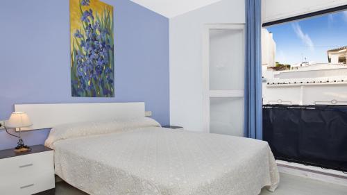 1 dormitorio con cama blanca y ventana en 1Solive - Calella de Palafrugell en Calella de Palafrugell