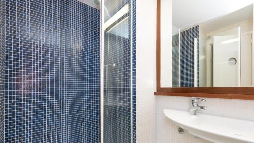 a bathroom with a sink and a shower with a mirror at 1Solive - Calella de Palafrugell in Calella de Palafrugell