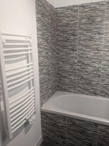 La salle de bains est pourvue d'une douche, de toilettes et d'une baignoire. dans l'établissement Appartement 200m de l'océan avec piscine extérieure, à Mimizan