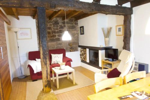 a living room with a red couch and a fireplace at Casas Rurales El Mayorazgo in Cordovilla de Aguilar