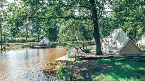 kilka namiotów i łódź na rzece w obiekcie ASILI DELUXE - Zebra w mieście Lichtaart
