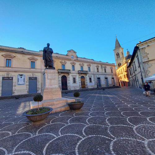 a statue in the middle of a street with a building at Ars Amandi in Sulmona