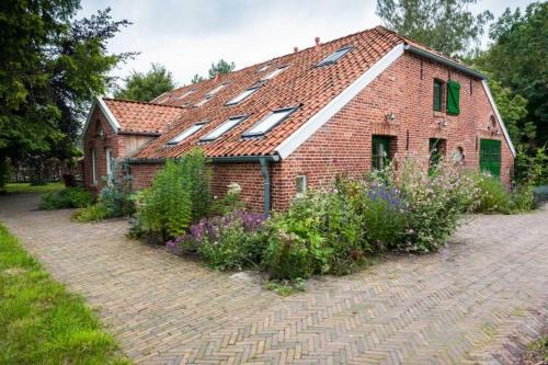 a brick house with windows and flowers in front of it at Ferienwohnung 1 Holthusen 25514 in Weener