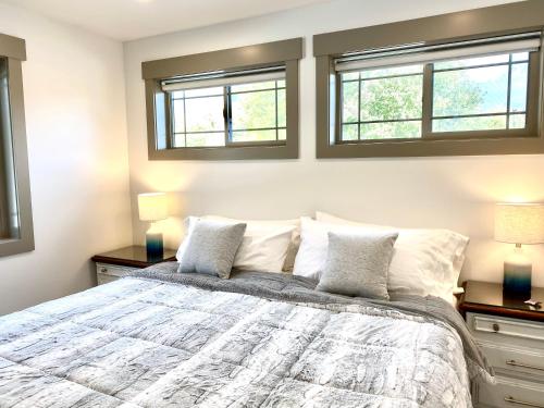 una camera da letto con un grande letto con due finestre di The Raspberry Garden a Rexburg