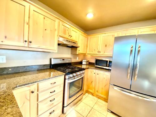 a kitchen with wooden cabinets and a stainless steel refrigerator at The Raspberry Garden in Rexburg