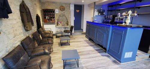 - un bar avec un comptoir bleu et quelques chaises dans l'établissement Hôtel Restaurant Le Mulberry Arromanches, à Arromanches-les-Bains