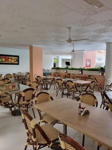 an empty restaurant with tables and chairs and a ceiling at Zahira Hotel Melgar in Melgar