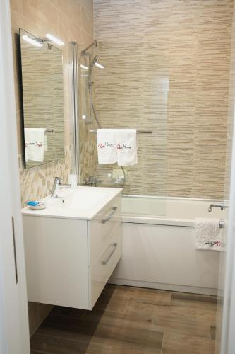 a white bathroom with a sink and a shower at ResHome Apartments&Rooms in Focşani