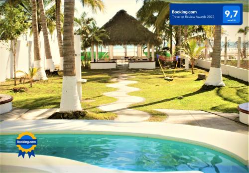 a swimming pool in front of a resort with palm trees at Casa Matanchen, privada a pie de playa & kaayaks in San Blas