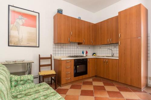 a kitchen with wooden cabinets and a couch in a room at I Giardini Di San Vito in San Vito lo Capo