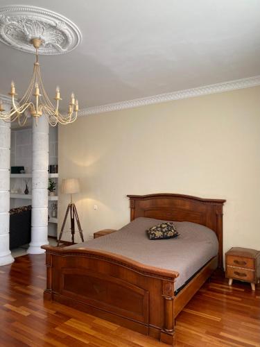 um quarto com uma cama e um lustre em Просторная солнечная студия с круглым балконом em Vyborg