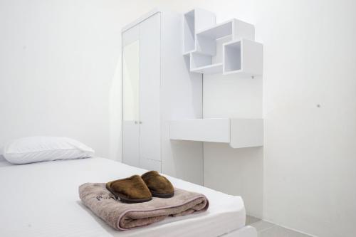 a white room with a bed with two towels on it at Omah Ninten Syariah RedPartner in Solo