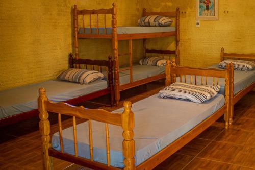a room with three bunk beds in a room at Pequizeiro Eco Pousada in Cavalcante