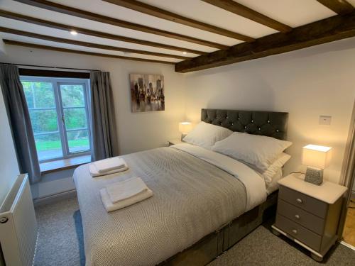 - une chambre avec un grand lit et une fenêtre dans l'établissement Swan House Tea Room and Bed & Breakfast, à Lydney