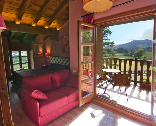 a living room with a red couch and a balcony at Casa Rural Urkulu Landetxea in Aretxabaleta
