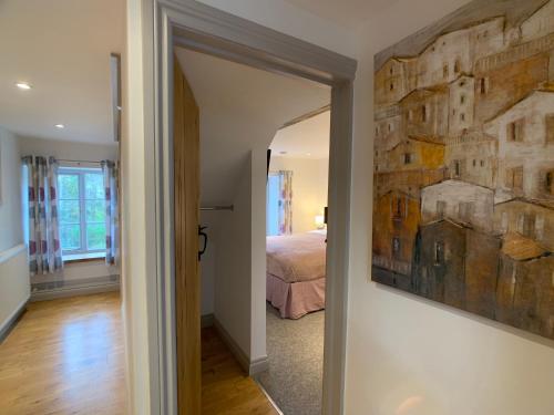 a bedroom with a bed and a painting on the wall at Swan House Tea Room and Bed & Breakfast in Lydney