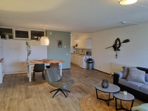 a living room with a couch and a table at Beach appartement Strandslag 129 in Julianadorp
