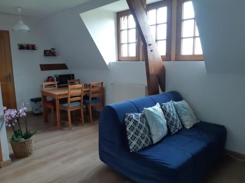 ein blaues Sofa im Wohnzimmer mit einem Tisch in der Unterkunft Relais équestre du Miloir - chambres d'hôtes in Saint-Martin-de-la-Lieue
