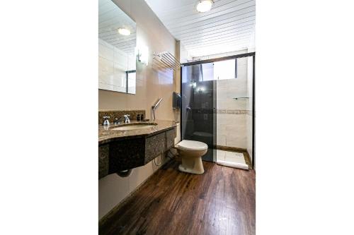 uma casa de banho com um WC, um lavatório e um chuveiro em Piscina no Rooftop com Vista Ponte e Mar #CA22 em Florianópolis